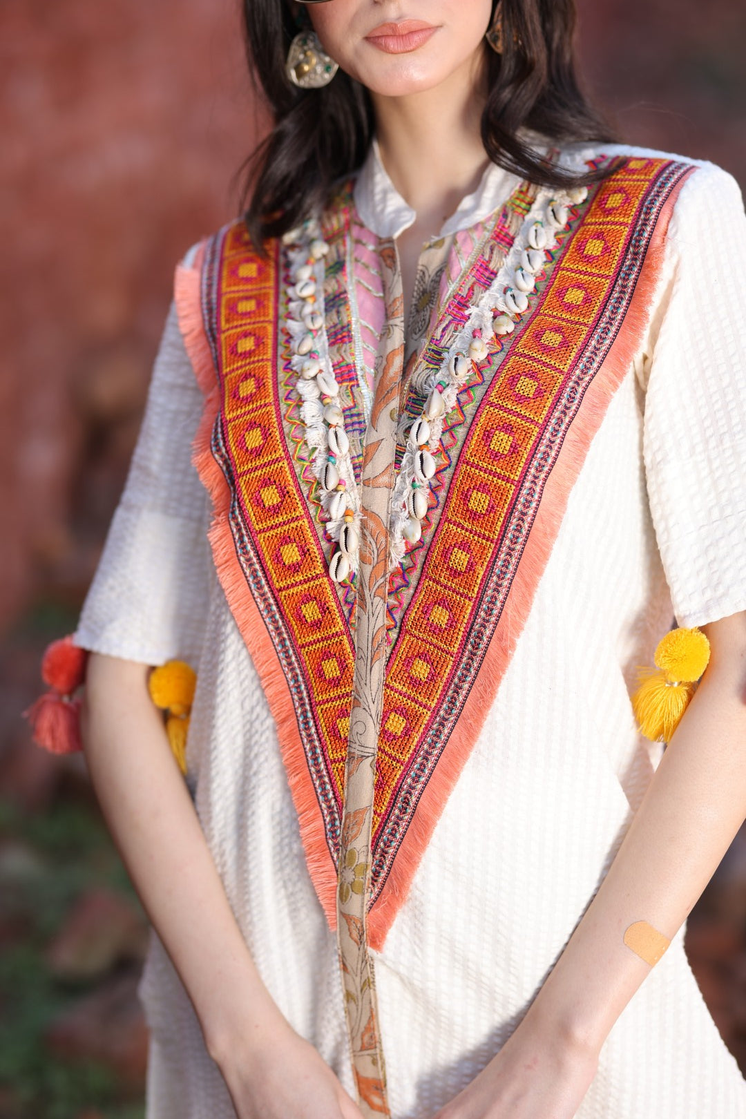 Embroidered yoke and colorful tassel close-up.