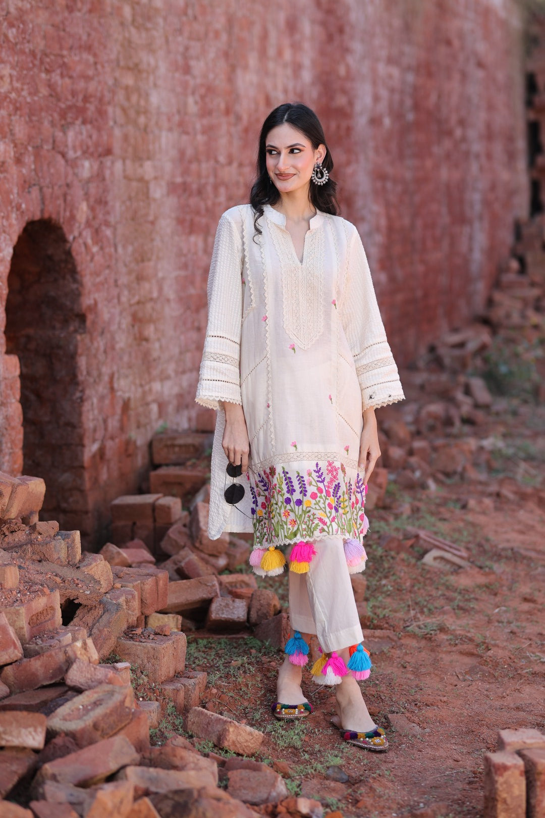 Model wearing ivory embroidered kurta with multicolour tassels and matching straight pants.