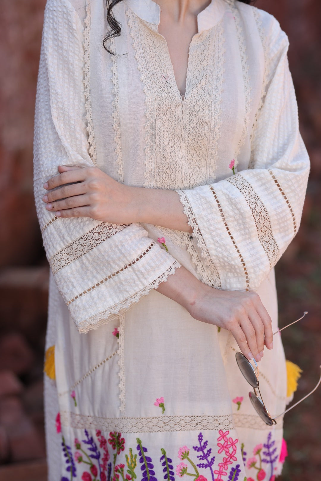 Close-up of hemline embroidery, vibrant tassels, and matching juttis.
