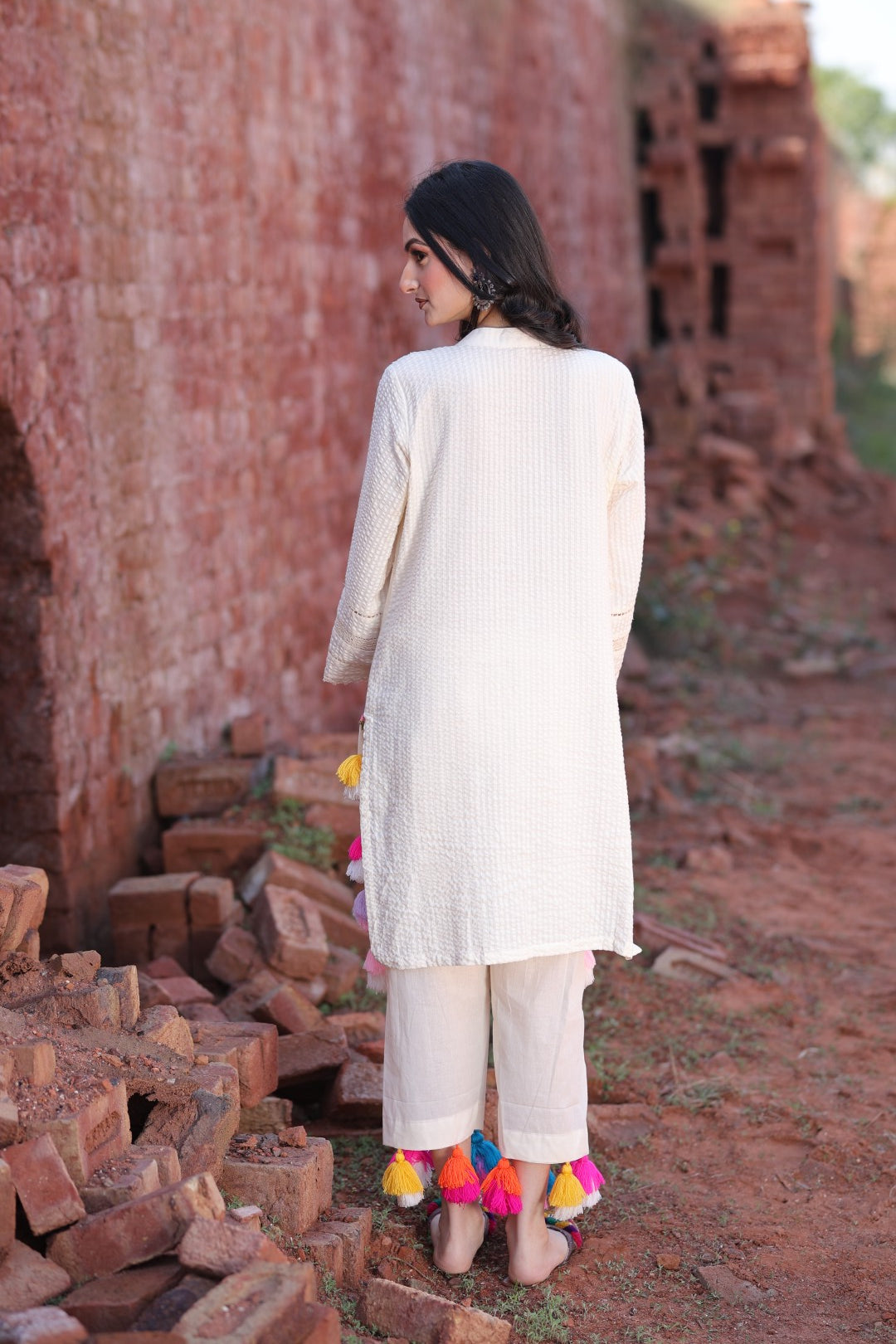 Rear angle showing relaxed kurta fall and tassels on pant hem.