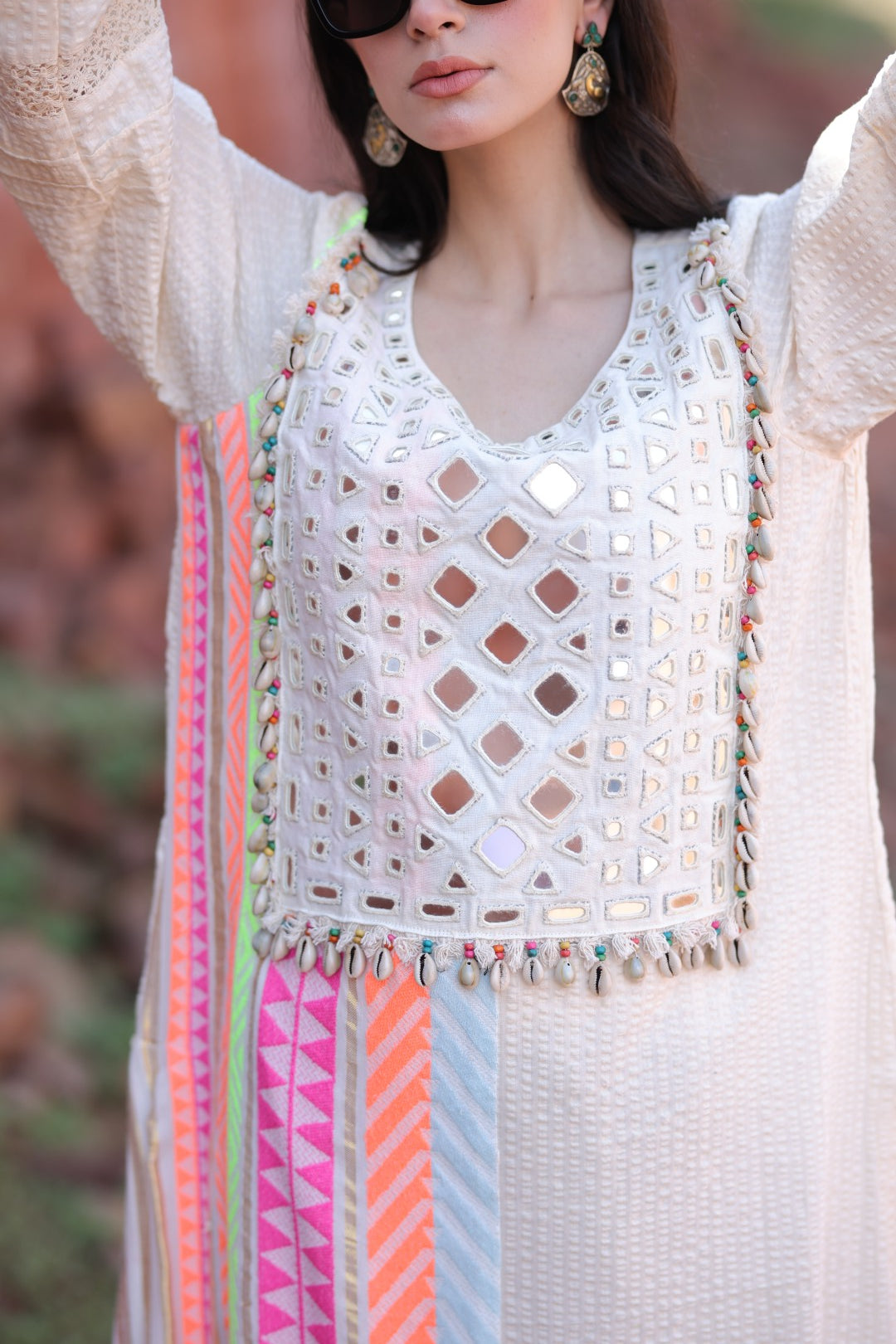 Macro of mirror embroidery, pastel tapes and handmade tassels in motion.