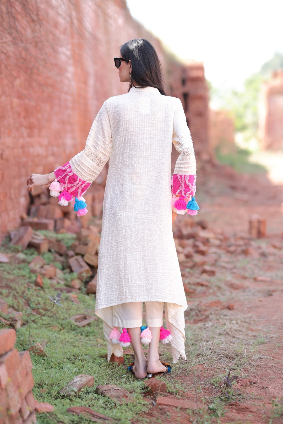 Flowing back view of ivory kurta set with textured fabric and asymmetrical hem