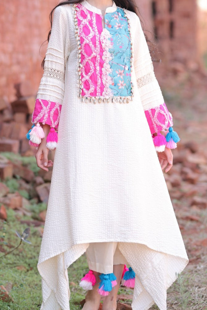 Zoomed-in embroidery with tassels and shell accents on kurta and pant hem