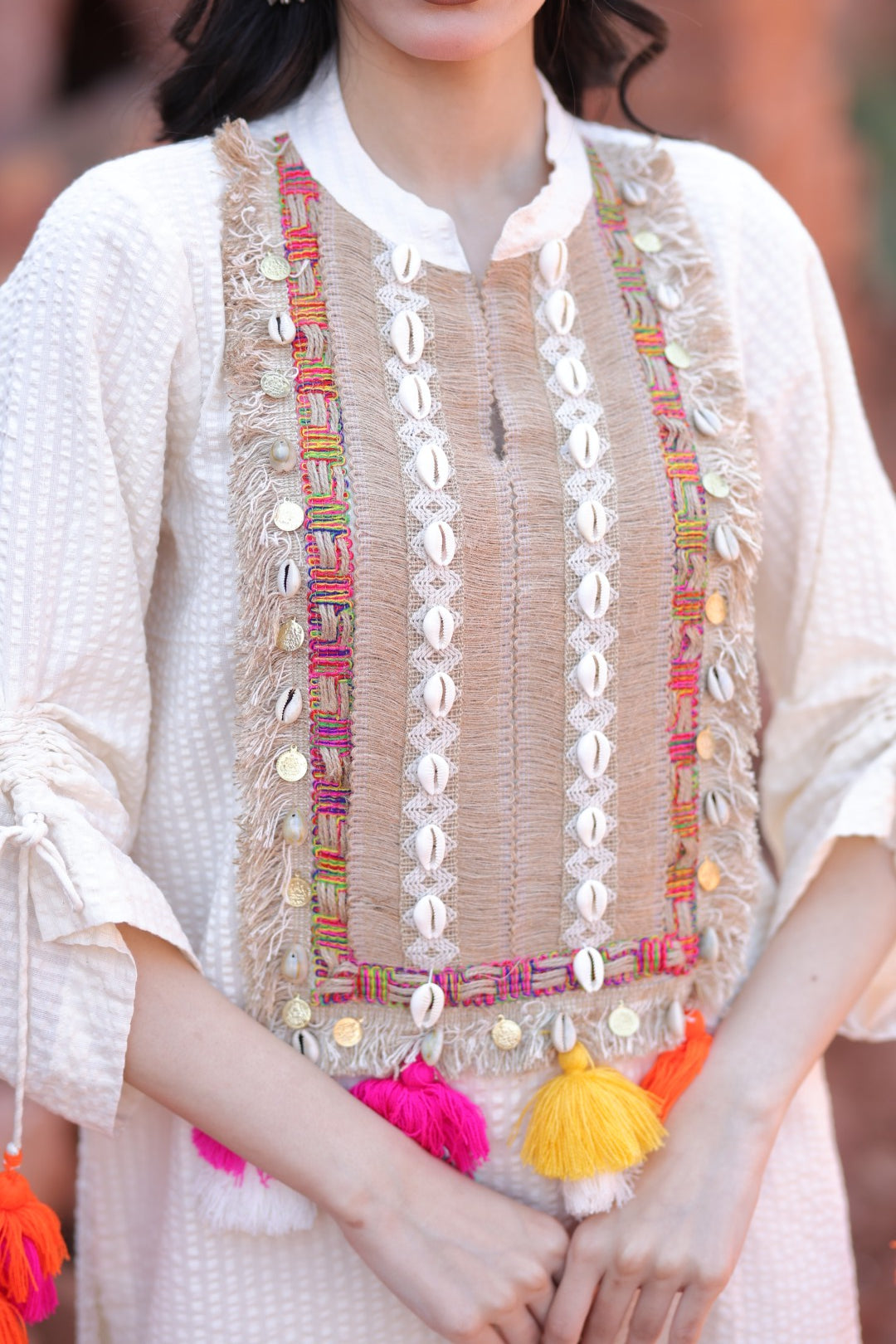 Close-up of patchwork embroidery, mirror embellishments and playful tassels.
