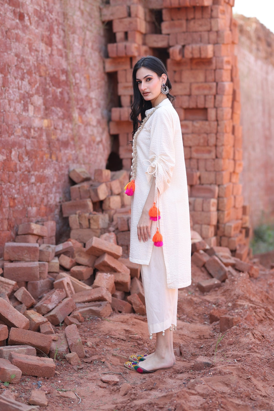 Side angle showing tassel detailing on sleeve and hem.