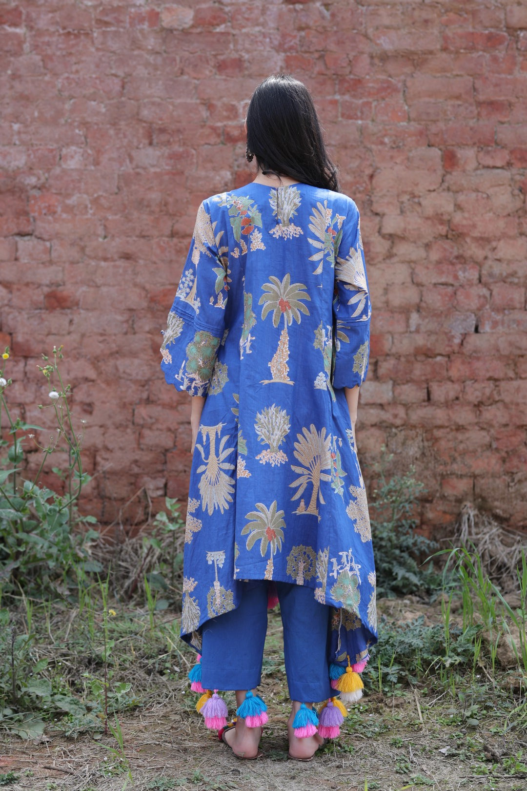 Back silhouette showcasing tassel detailing and garment fall