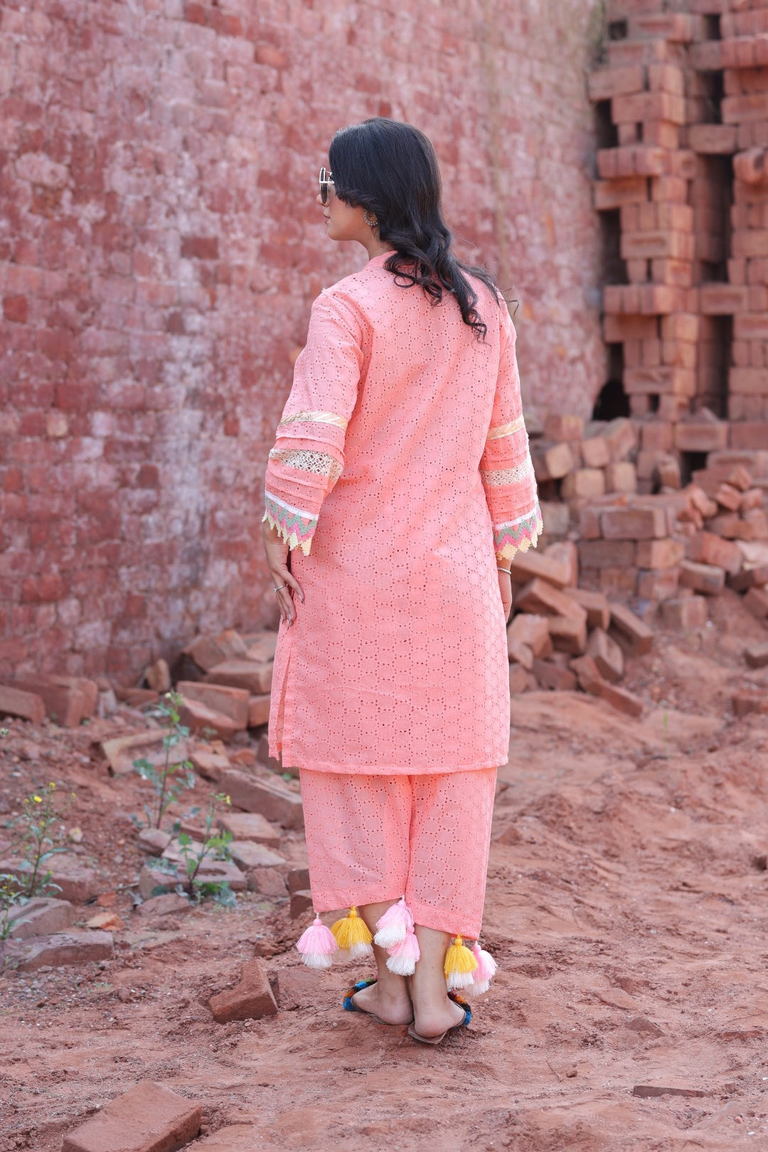 Back view of peach embroidered kurta and pants with tassel detail