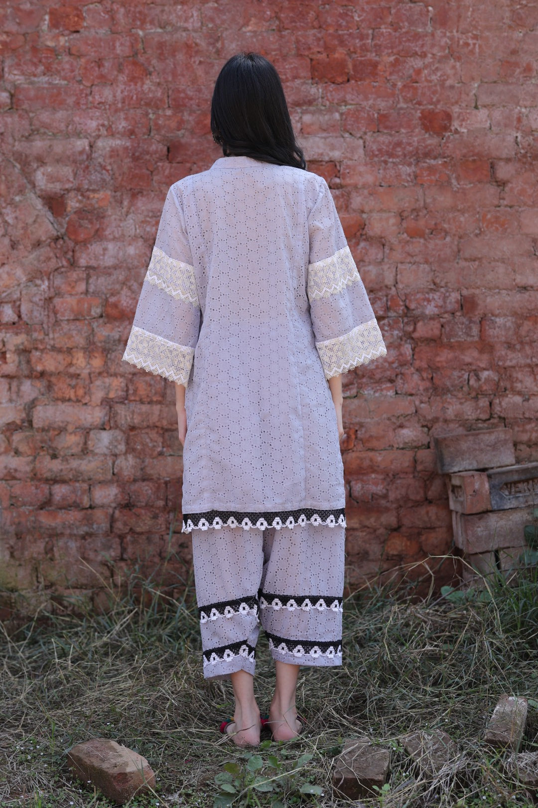 Back silhouette of the kurta against rustic brick wall