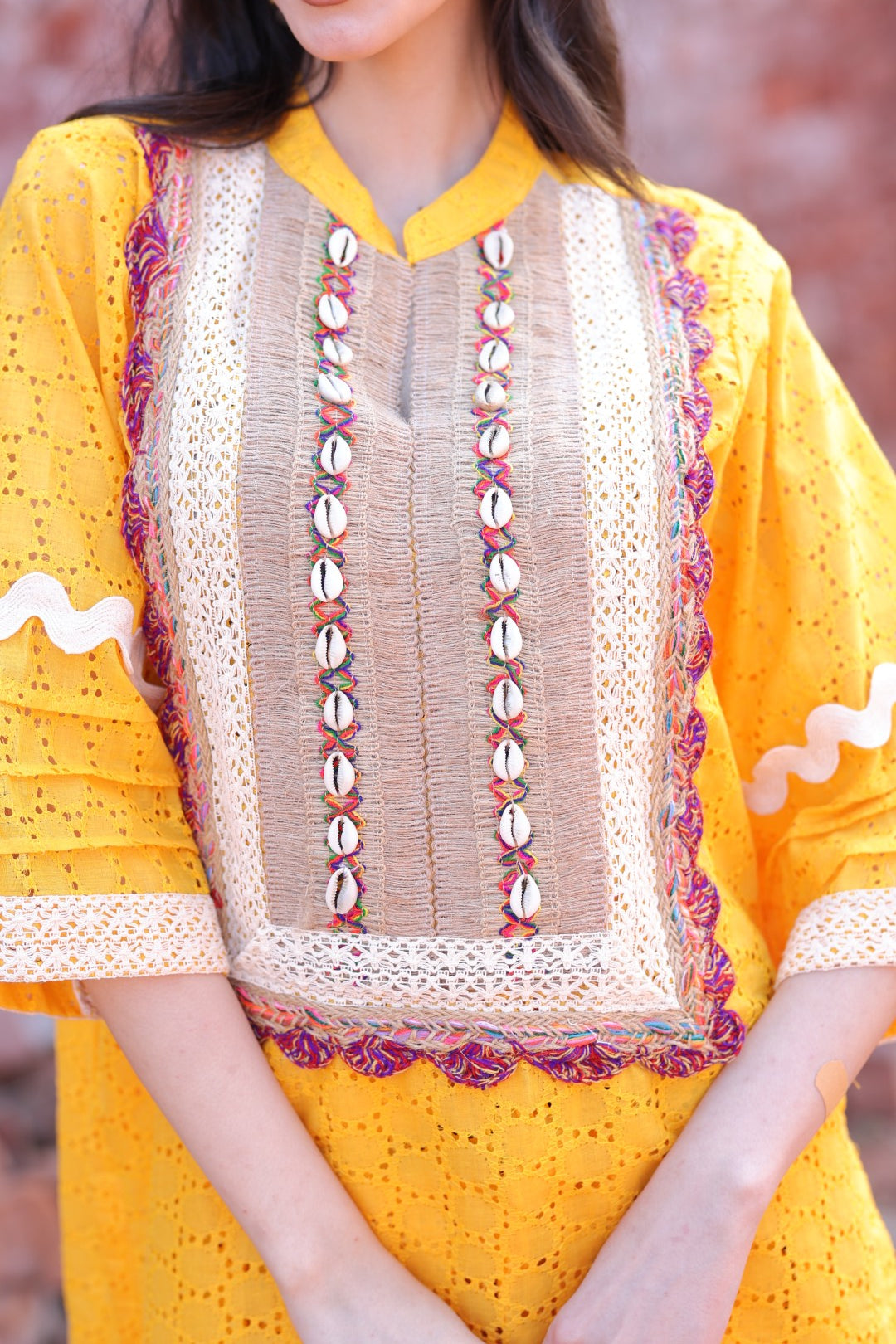 Close-up of placket with shells, mirrors, and hand-tied tassels