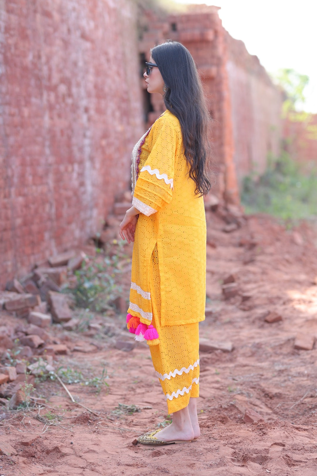 Side profile highlighting sleeve lacework and tassel play