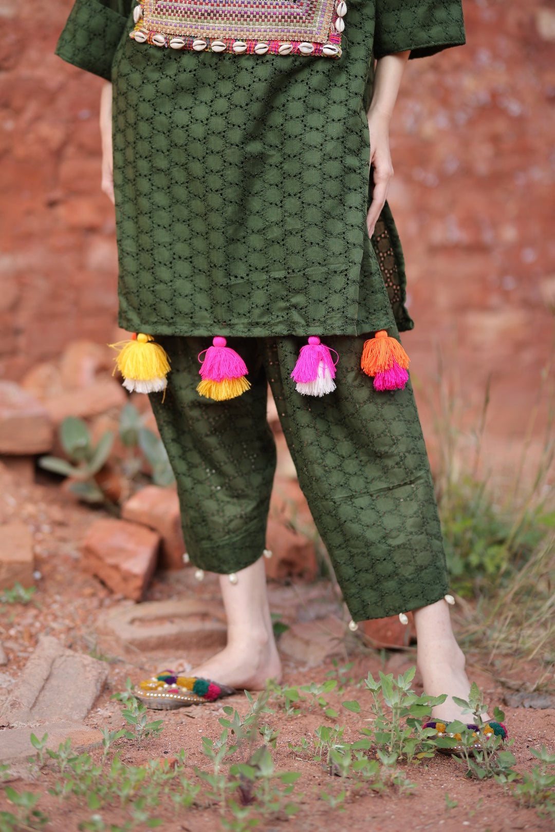 Close-up of embroidered yoke with shell buttons, lace, and mirror work