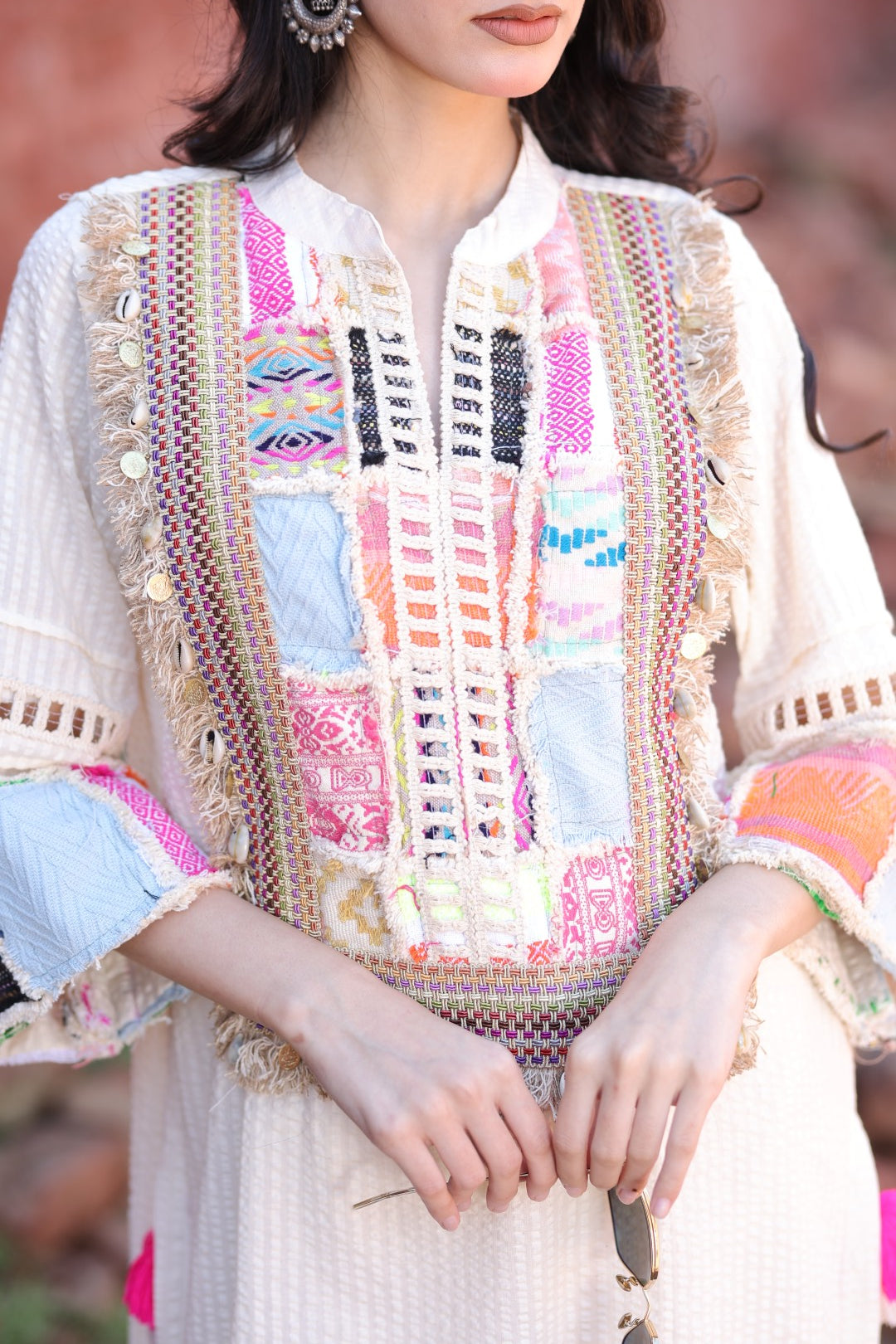 Close-up of patch embroidery in multicolour threads and mirror accents