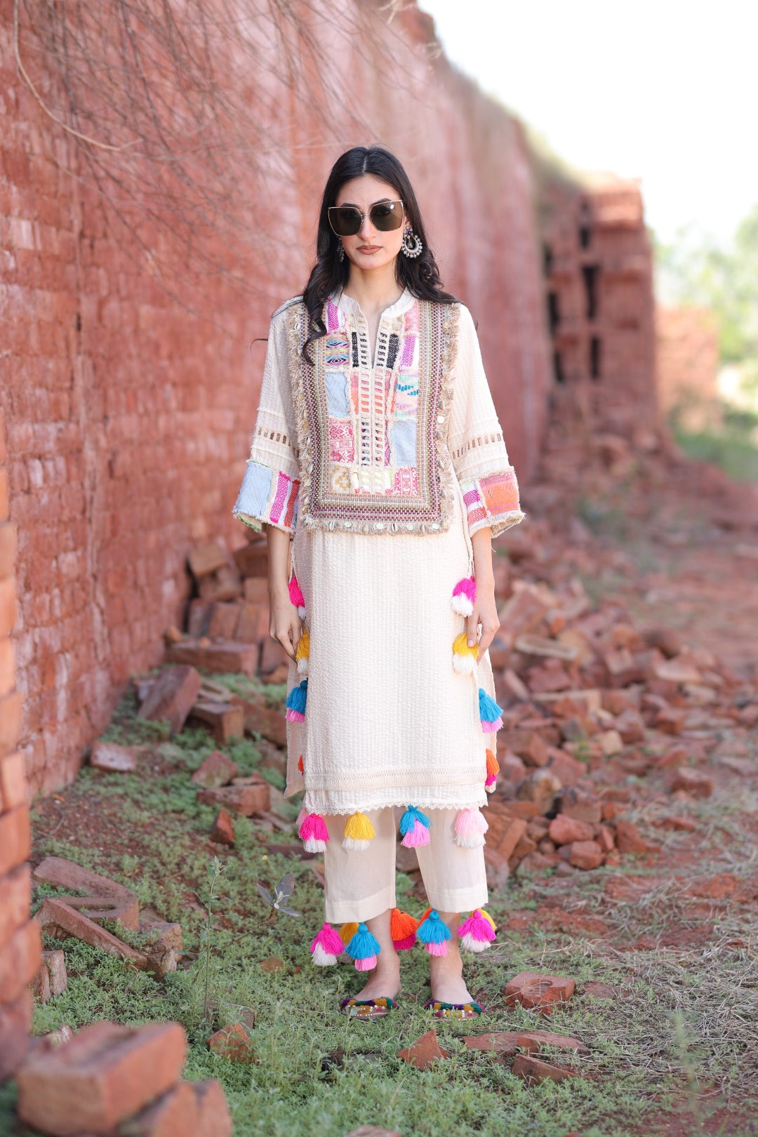Front view of ivory kurta with colourful patch embroidery and tassels by Mani Dua Khanna