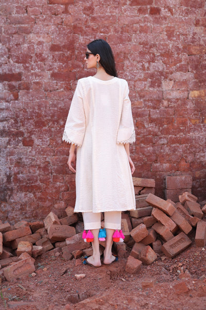 Back profile of the ivory kurta, showcasing fabric flow and tassel fall