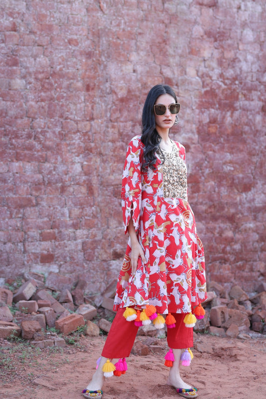 Model wearing red bird print kurta with mirror yoke and tassels, front view